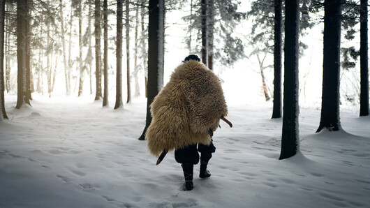 Illustrasjonsfoto av mann i tradisjonelle vikingklær som går gjennom skogen