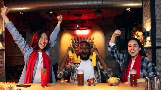 Three persons celebrating at a bar