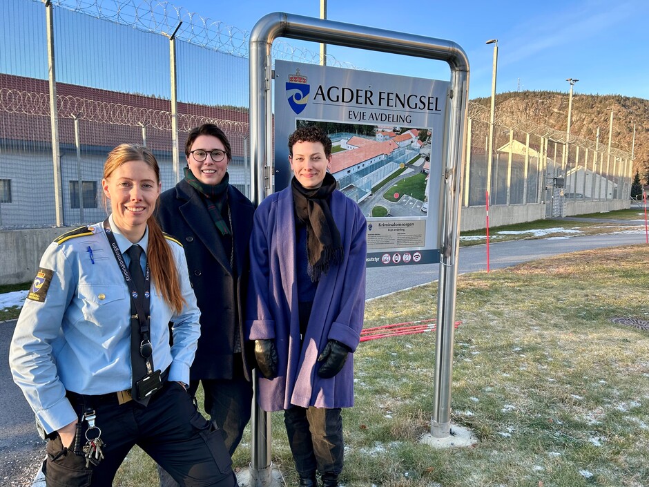 Ragnhild O. Nomeland fra Agder fengsels avdeling på Evje sammen med Senter for likestillings Thea Litschi og Mary Ann Skretteberg Andersen står foran Evje fengsel. Bak dem ser vi et høyt gjerde og bak der noen av bygningene til fengselet. 